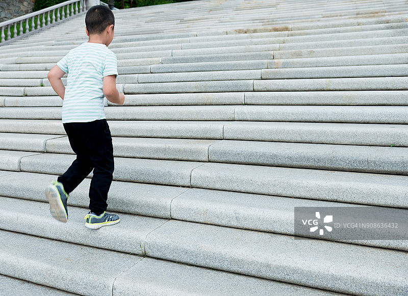 在户外爬楼梯的小男孩图片素材