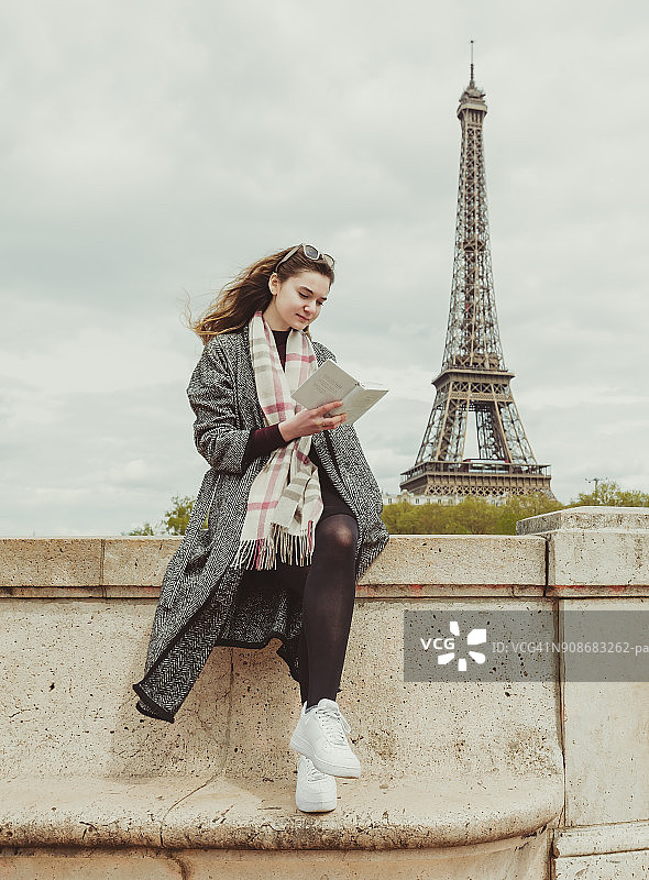 年轻女人在塞纳河沿岸看书图片素材