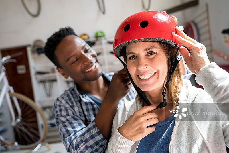 在自行车店试戴头盔并对着镜头微笑的女顾客图片素材