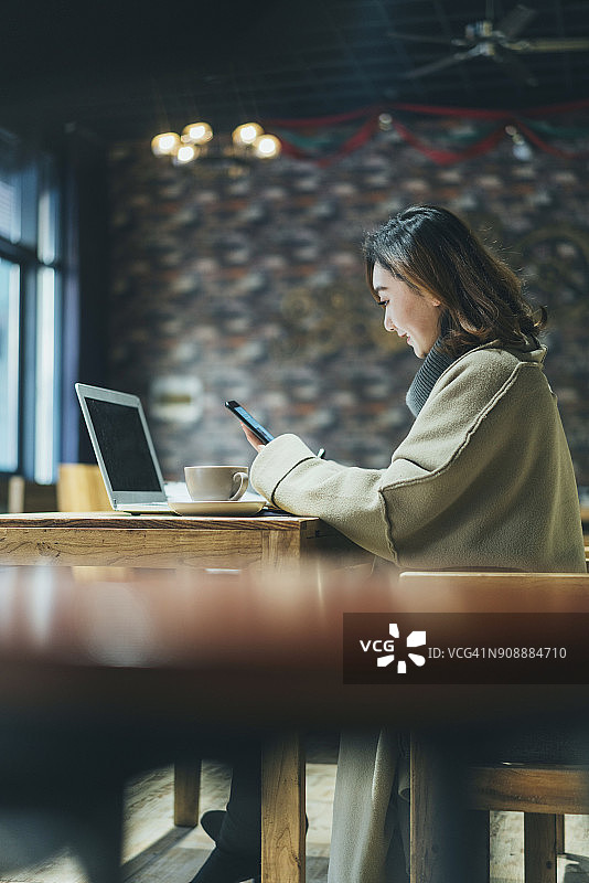 用智能手机发短信的开心的女人图片素材