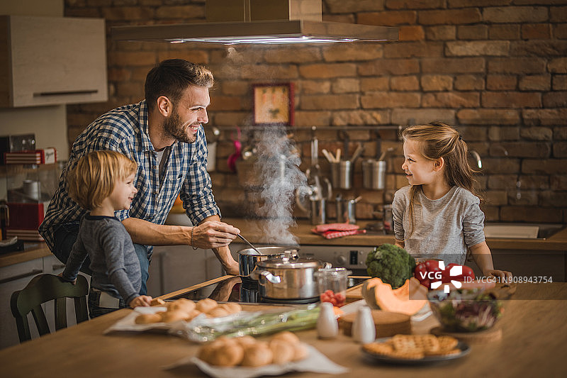 单亲父亲和孩子们在厨房准备午餐图片素材