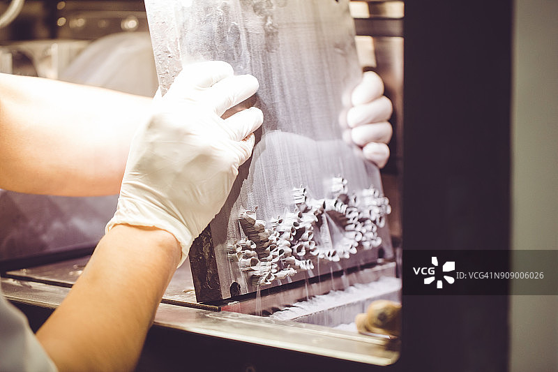 牙科技师从3D粉末打印机中取出假牙图片素材
