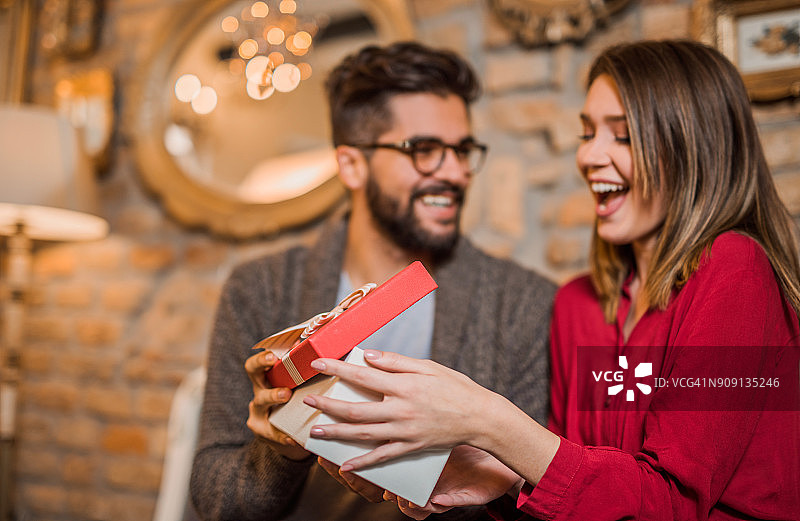 快乐的年轻女人收到男友的礼物图片素材