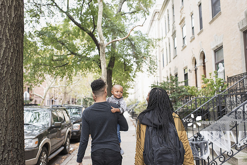 年轻家庭在城市社区中散步图片素材
