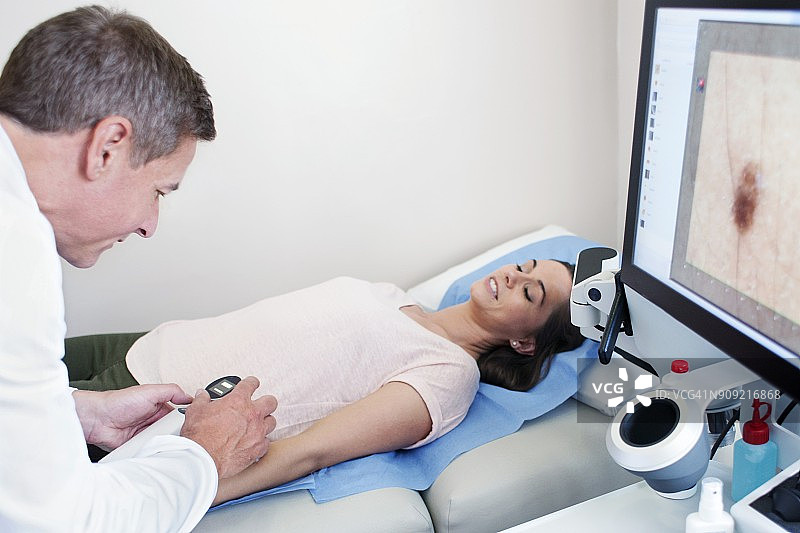 医生检查患者手臂上的痣图片素材