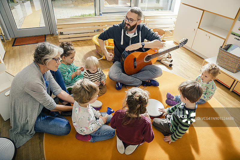 幼儿园里唱歌做音乐的儿童和老师图片素材