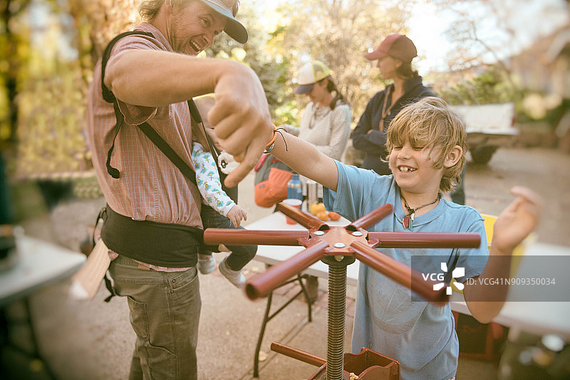 农场上父子使用苹果榨汁机图片素材