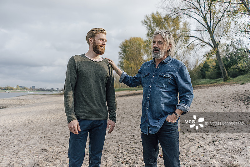 父子在莱茵河畔散步交谈图片素材