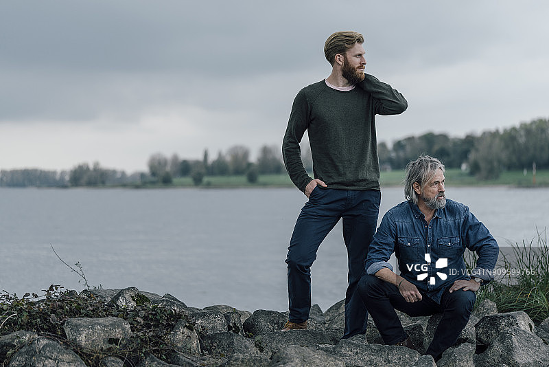 父子在户外一起度过时光，在石头上休息图片素材