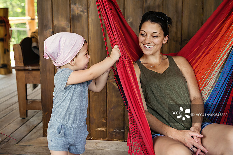 千禧一代母亲在夏日别墅户外与女儿放松图片素材