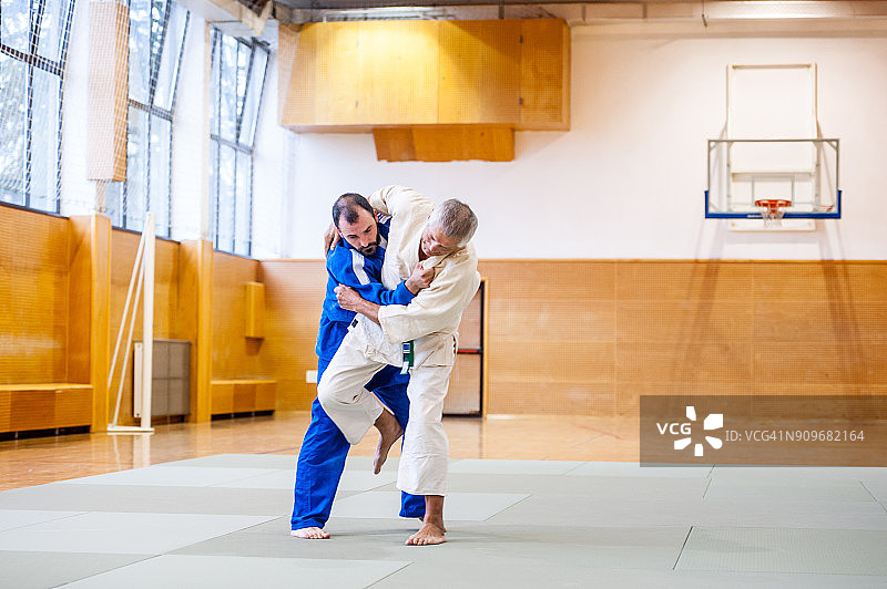 在柔道比赛中试图击倒对手的年长男人图片素材