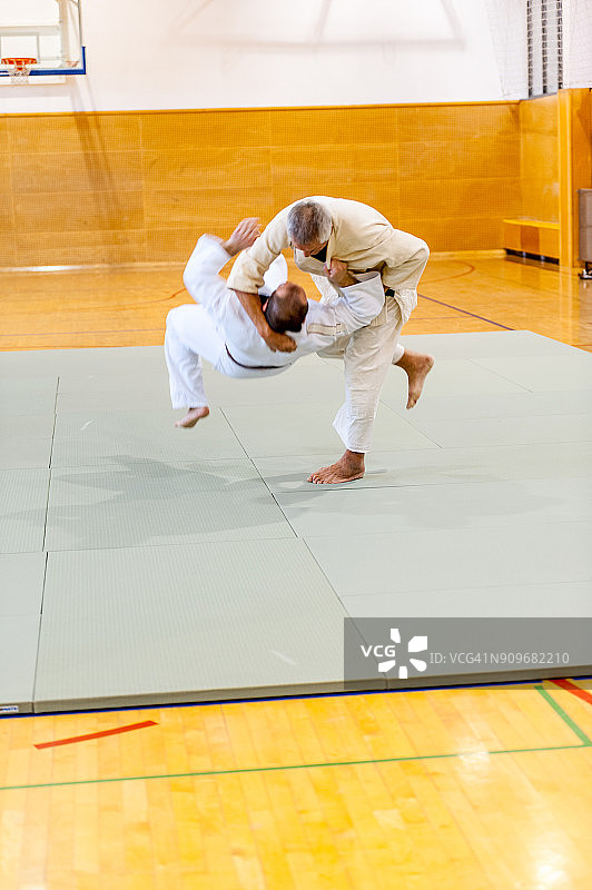 年长的柔道选手将对手摔倒在地图片素材