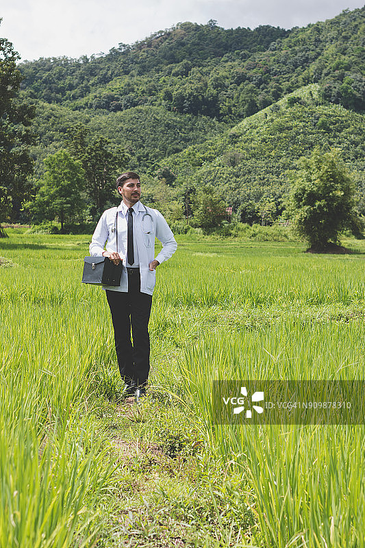 年轻医生在绿色中指向未来图片素材