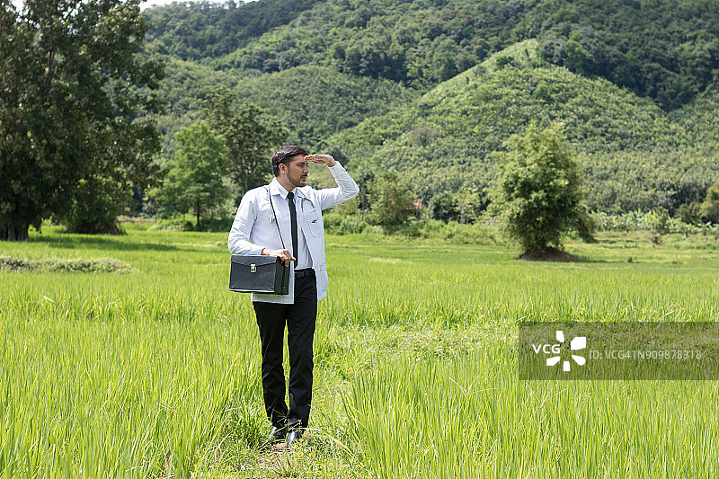 年轻医生在绿色中指向未来图片素材