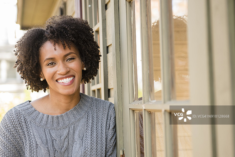 倚靠在入口门上的微笑女人肖像图片素材