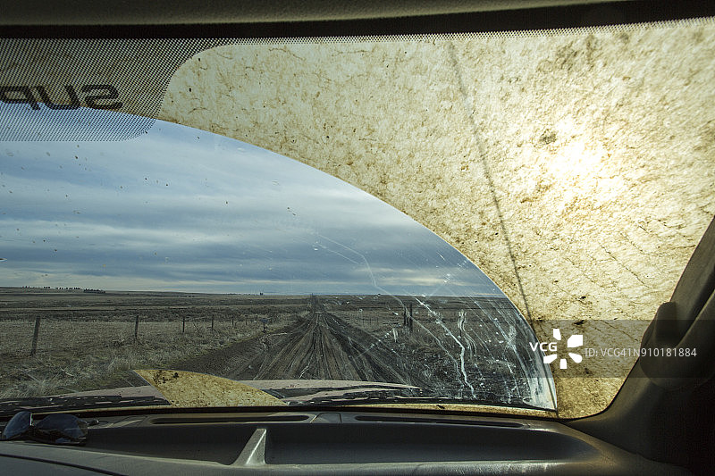 穿越俄勒冈州草谷乡村土路的汽车泥泞挡风玻璃后视图图片素材