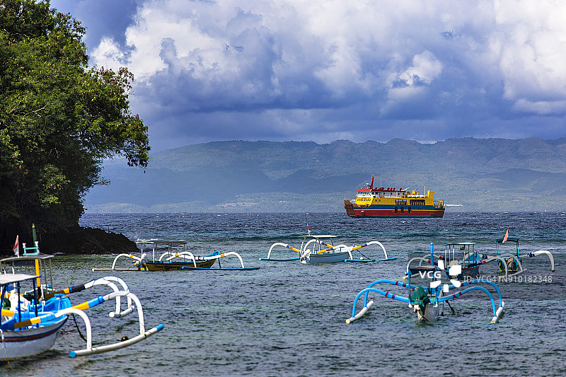 印度尼西亚巴厘岛和龙目岛之间的船只和渡轮上空的云彩图片素材
