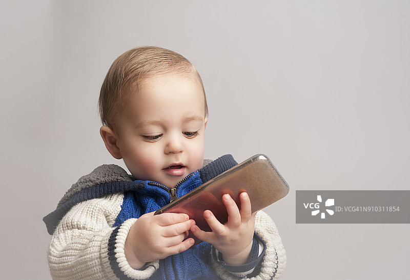 15个月大的异卵双胞胎拿着手机图片素材