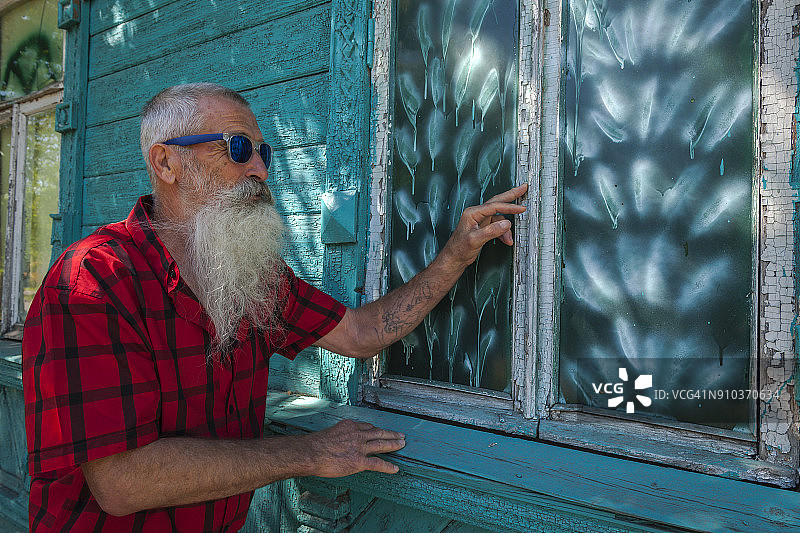 在俄罗斯河流中旅行的白胡子年长男人肖像图片素材