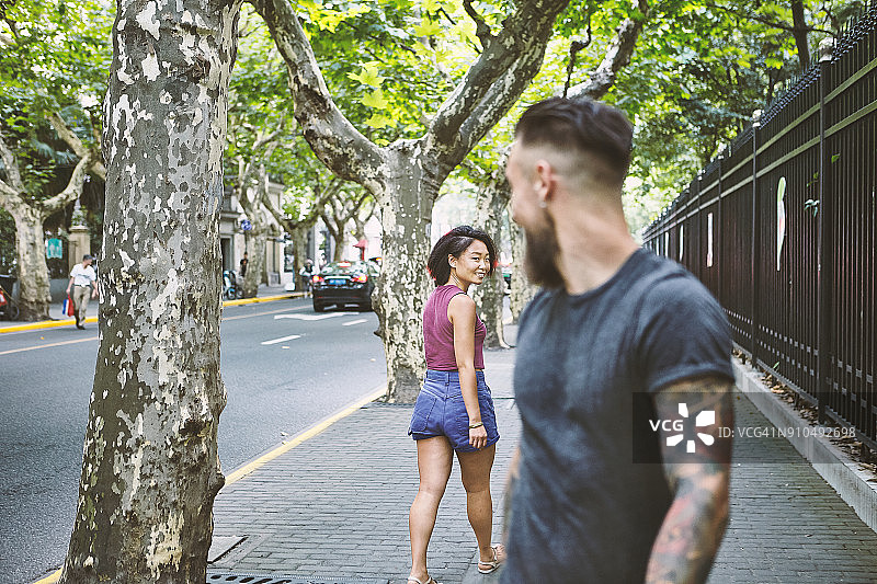 年轻男人和女人在上海法租界的人行道上回望图片素材