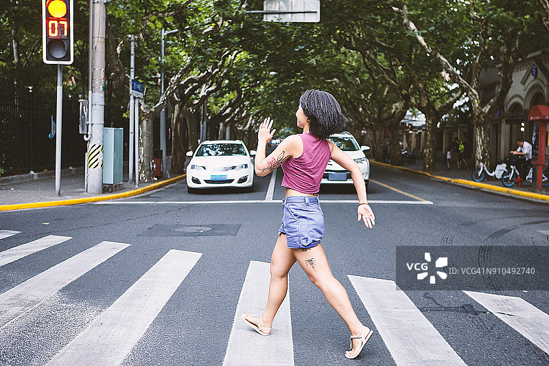 女人穿过上海法租界的斑马线，中国上海图片素材