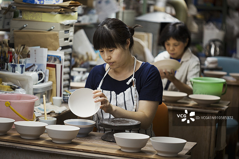 两位女士坐在工作室里制作日本瓷碗图片素材