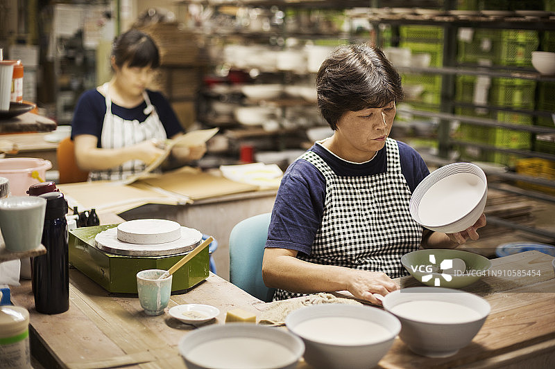两位女士坐在工作室里制作日本瓷碗图片素材