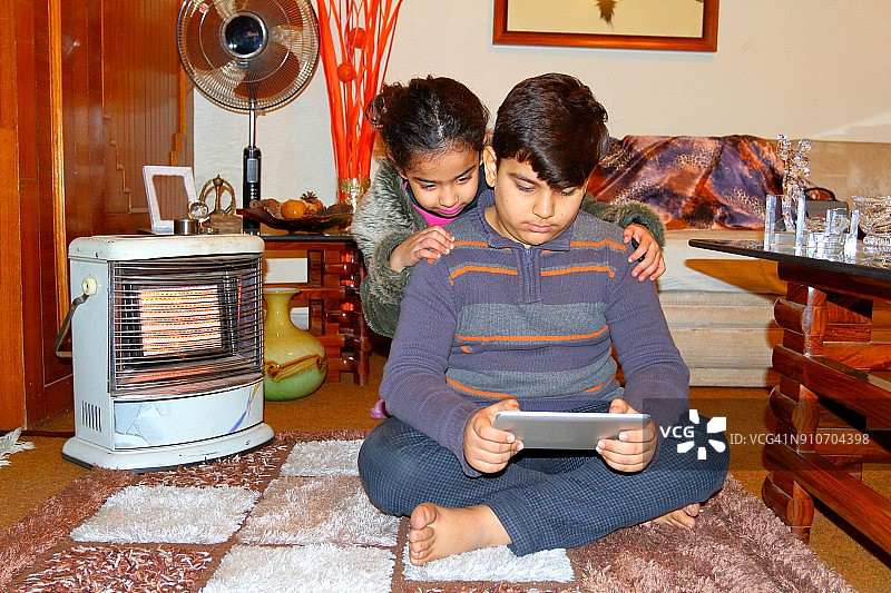 小女孩和小男孩愉快地使用平板电脑图片素材