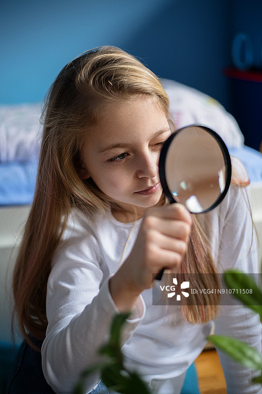 用放大镜观察的美丽女孩图片素材