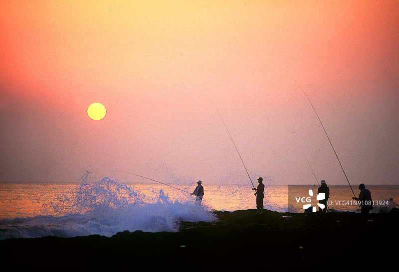海边渔民身影的日落景色图片素材