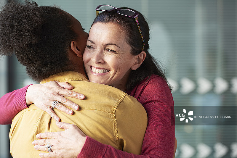 两名女子在工作中拥抱图片素材