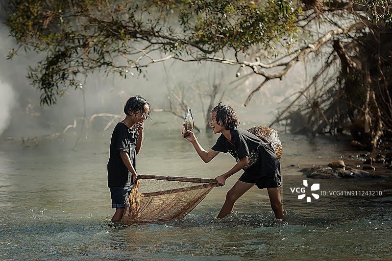 乡村儿童在河边钓鱼图片素材