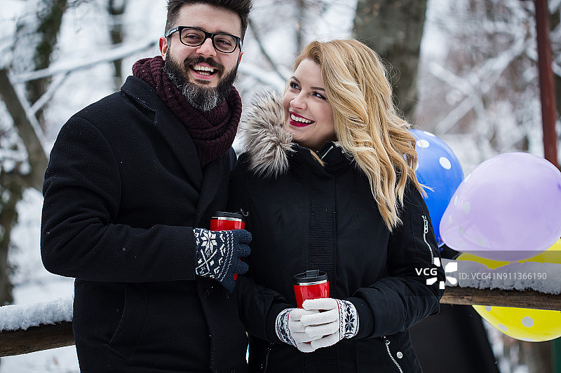 情侣在下雪的公园里喝咖啡图片素材