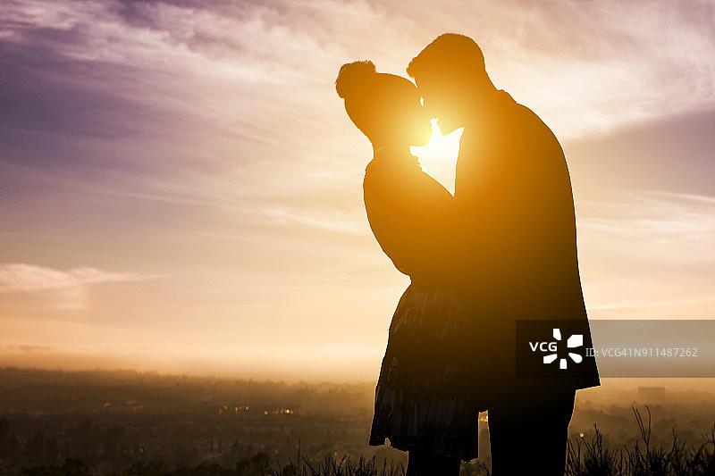 日落时分不同情侣订婚剪影图片素材