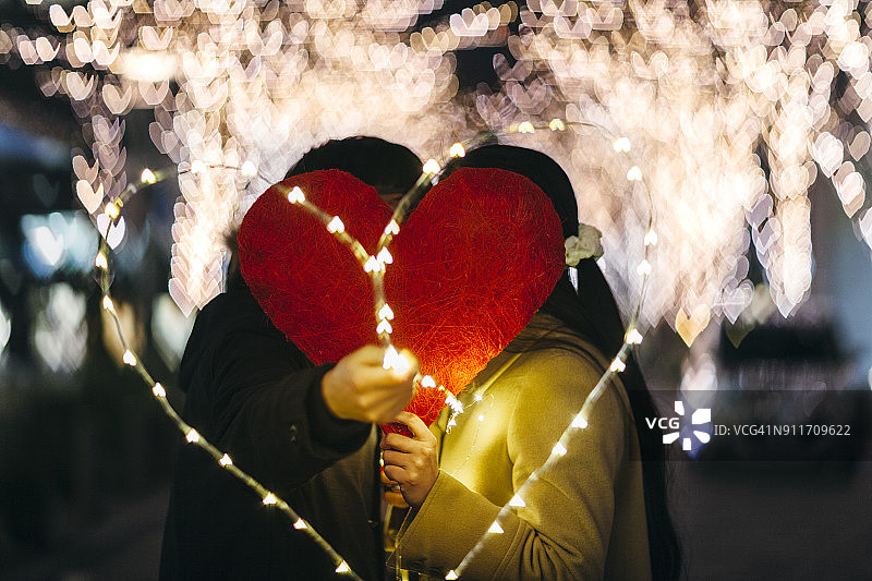 情侣在心形后面亲吻图片素材