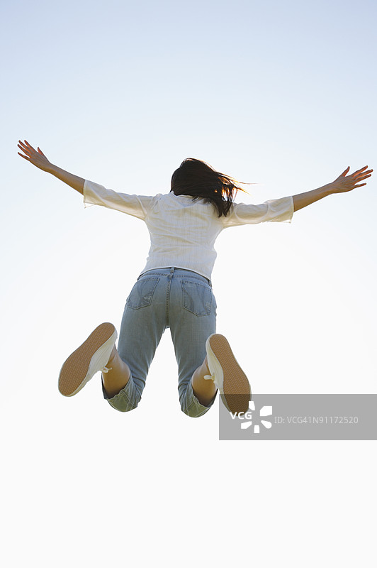 女人跳跃，背影视角图片素材