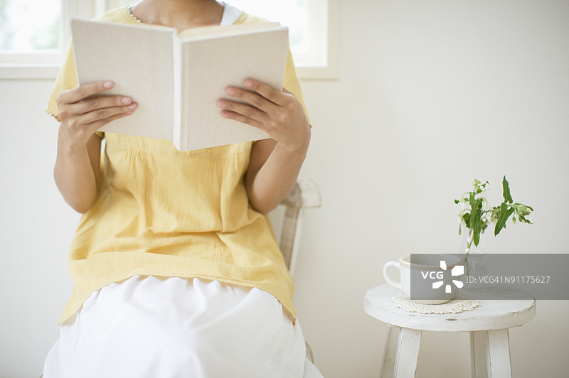 女性阅读书籍，腰部特写图片素材