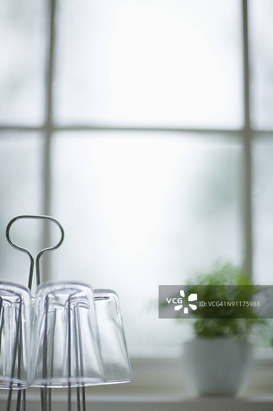 窗边的眼镜和盆栽植物，聚焦于前景图片素材
