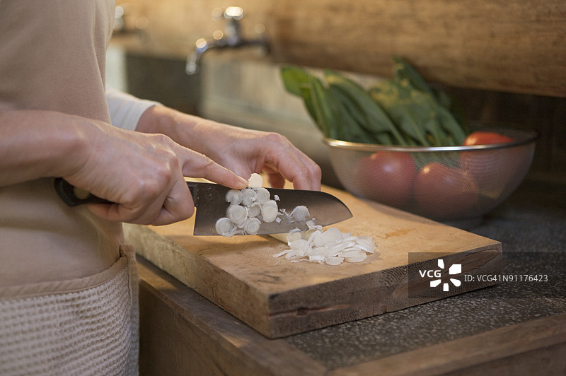 成熟的女性在传统日本厨房烹饪，特写手部。图片素材