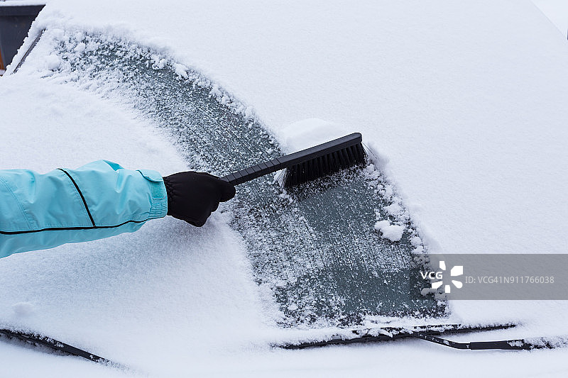 女人清理汽车上的积雪图片素材