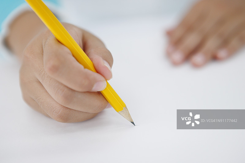 女孩握着铅笔，手部特写图片素材