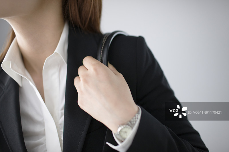 女商人拿着包，中部特写，工作室拍摄图片素材