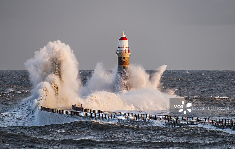波浪拍打着码头尽头的罗克灯塔图片素材
