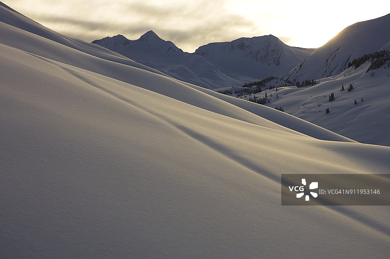 日落时分山脉中雪覆盖的山坡图片素材