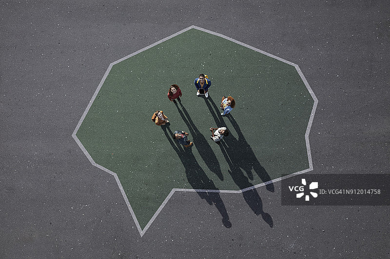 一群人站在沥青路面上画的语音气泡里，抬头向上看图片素材