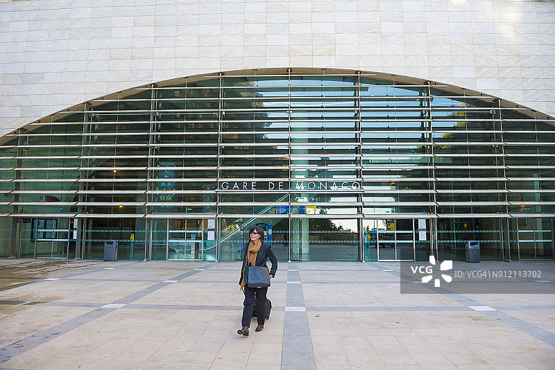 在摩纳哥火车站外手持行李车的女人图片素材