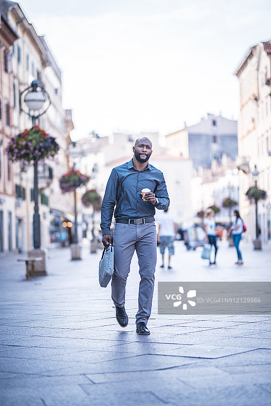 拿着咖啡杯奔波的商人图片素材