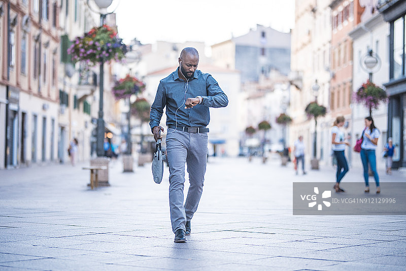 查看时间并走在街上的商人图片素材