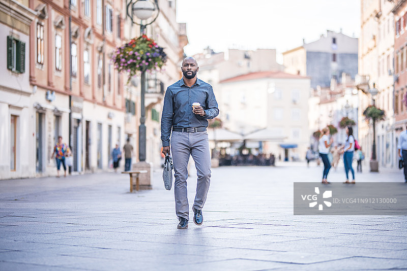 拿着咖啡杯奔波的商人图片素材