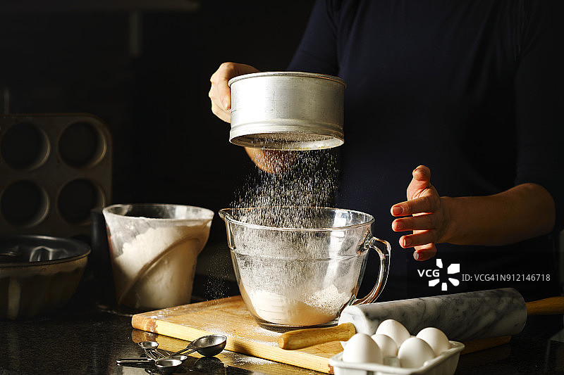 女人用筛子筛面粉图片素材